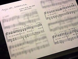 Replika ručno pisane ljestvice Majulah Singapura na izložbi u Nacionalnom muzeju Singapura. Original je trenutno izložen u Centru za Malajsku baštinu.