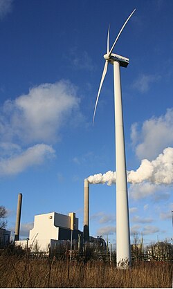 Picture showing smoke from chimneys and wind turbines indicating old and new human uses of the atmosphere